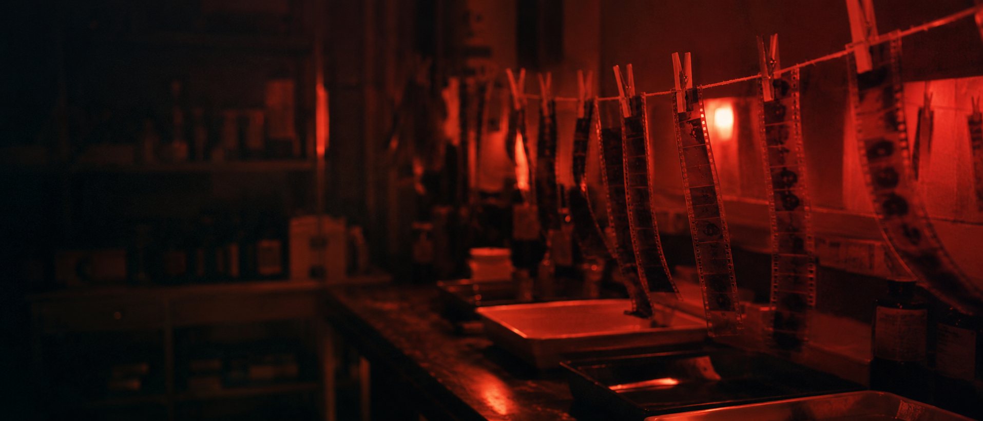 Negativos secándose bajo la luz roja del cuarto oscuro de Isla Film Lab